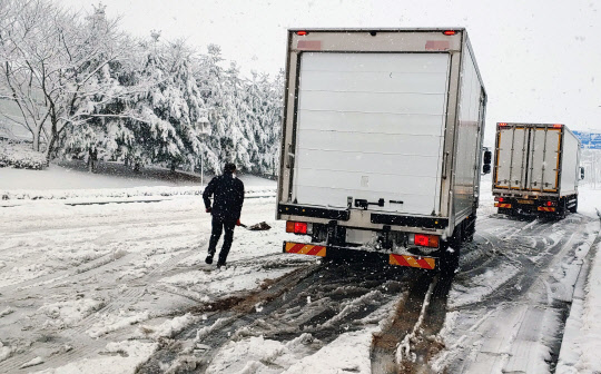 기습 폭설이 내린 1일 오후 강원 강릉 시내의 한 언덕길에서 트럭이 빙판길을 탈출하기 위해 안간힘을 쓰고 있다. <강릉=연합뉴스>